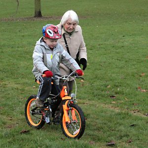 Child on bike with older person supervising
