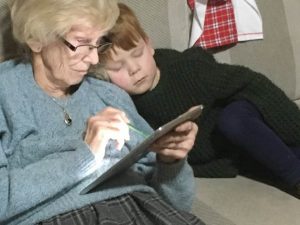 Grandparent and grandchild using an iPad